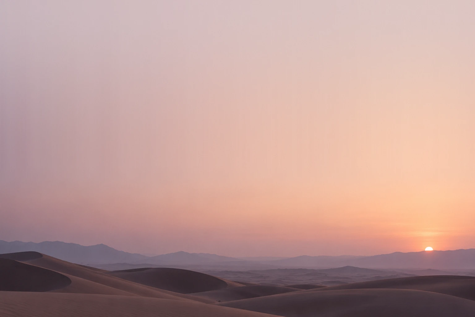 Soft pink dusk over desert dunes